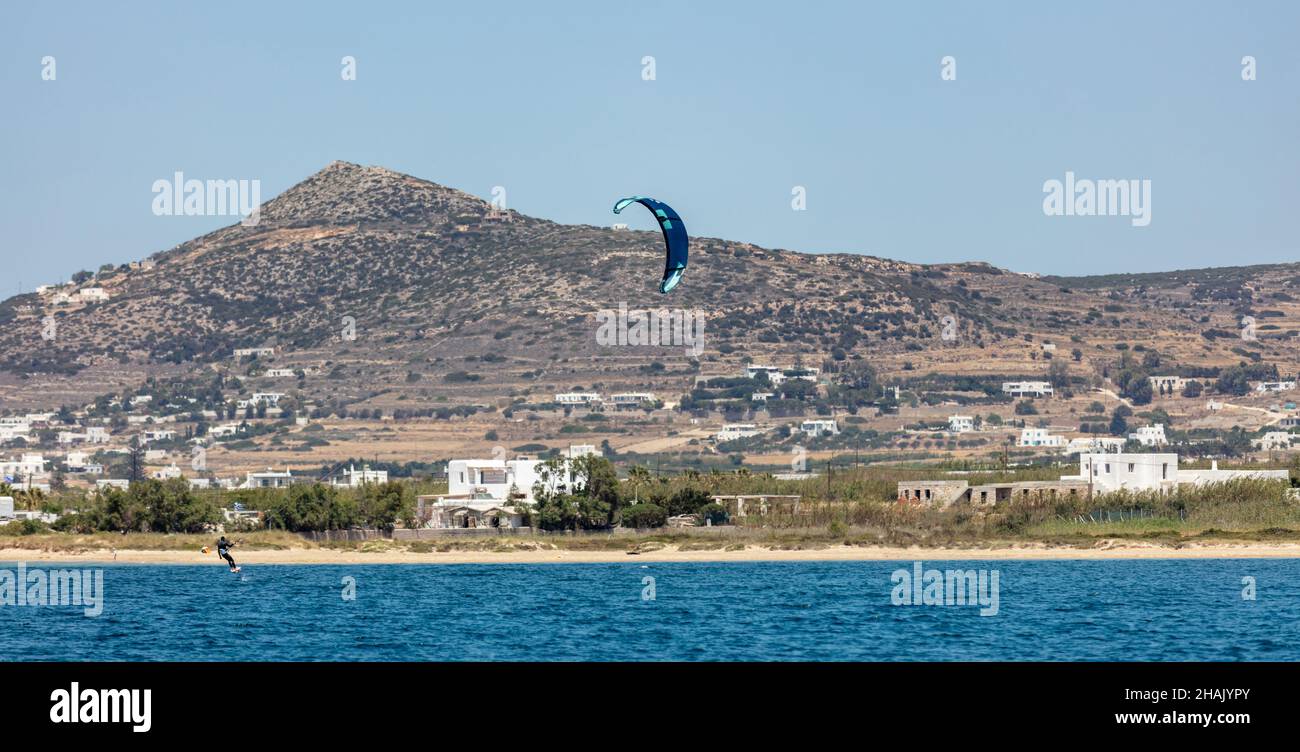Kitesurf nel mare blu Egeo a Pounta spiaggia Paros isola Cicladi Grecia. Kiteboarding, avventura sportiva estrema velocità. Foto Stock