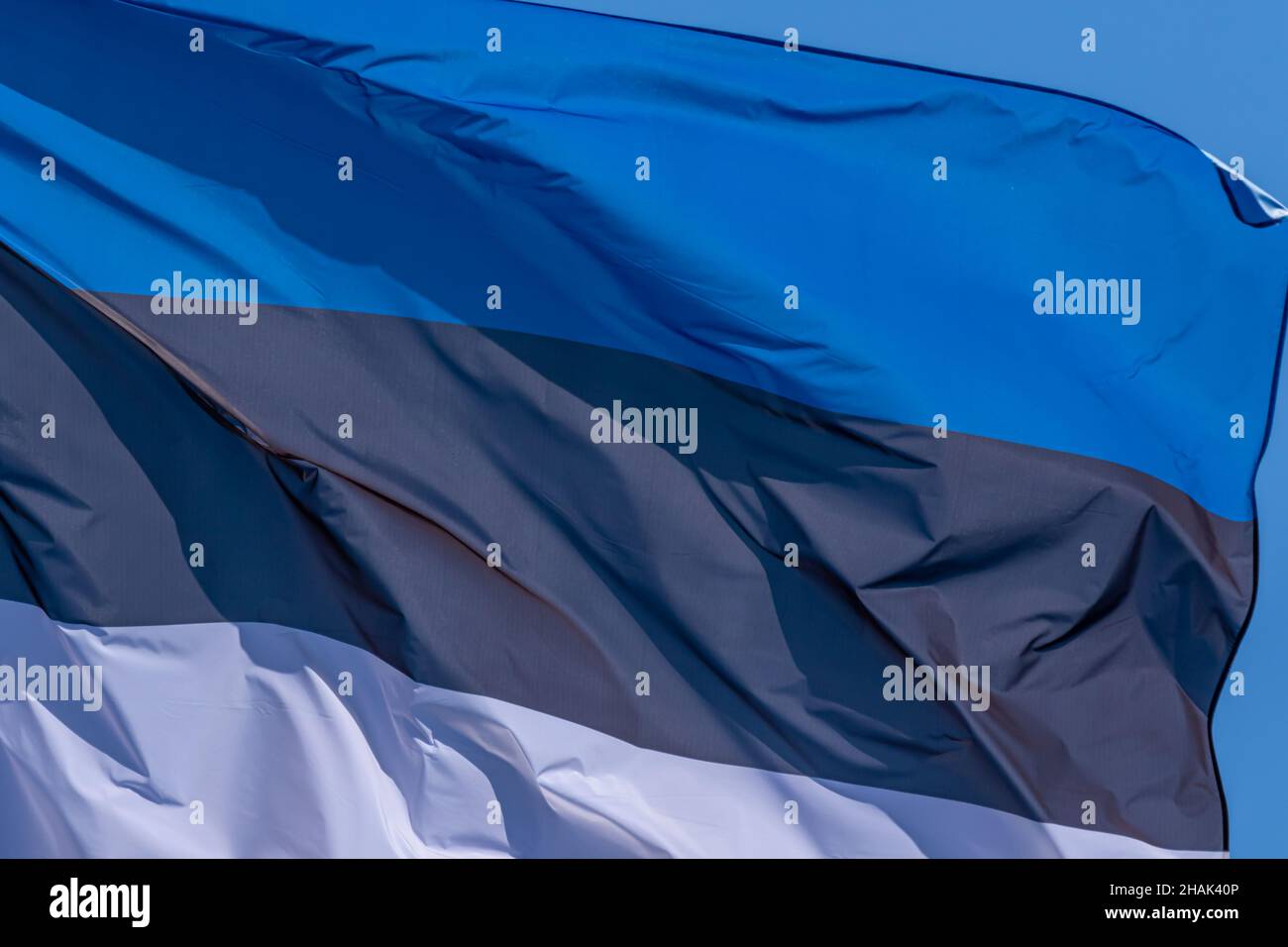 Parte della bandiera nazionale estone che sventola, primo piano. Repubblica di Estonia, EE Foto Stock