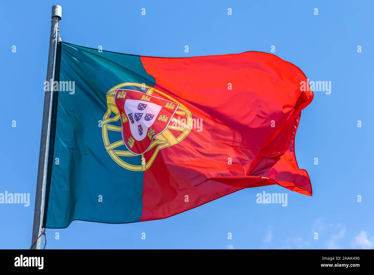 Bandiera nazionale portoghese che sventola su sfondo cielo blu. Repubblica portoghese, PT Foto Stock