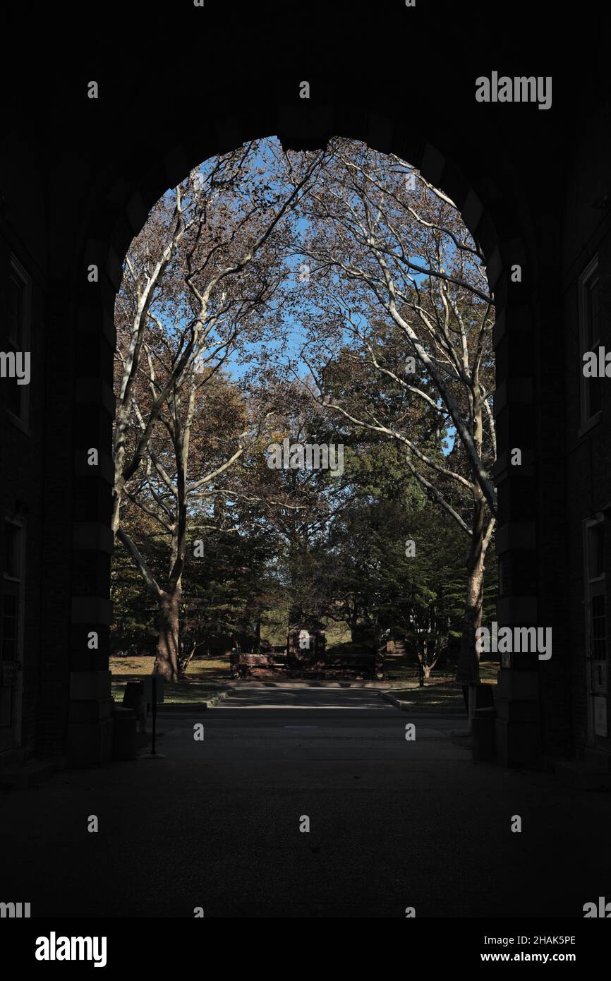 Vista attraverso il grande arco di Liggett Hall, un ex edificio caserma costruito nel 1929 vicino a Fort Jay su Governors Island nel porto di New York. Foto Stock