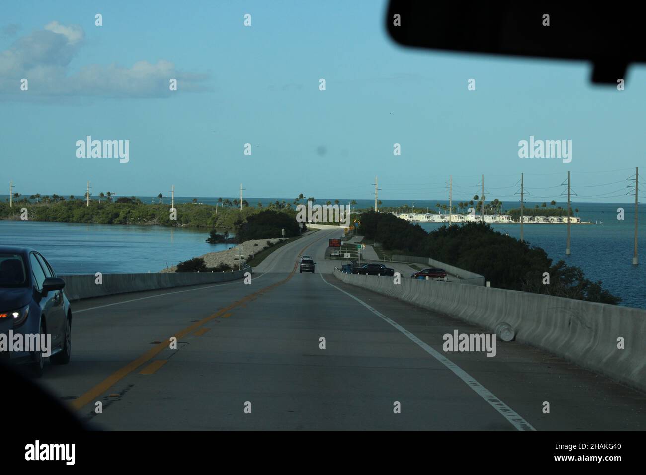 Auto lungo il ponte di sette miglia, con le Florida Keys sullo sfondo e l'acqua blu del Golfo del Messico Foto Stock