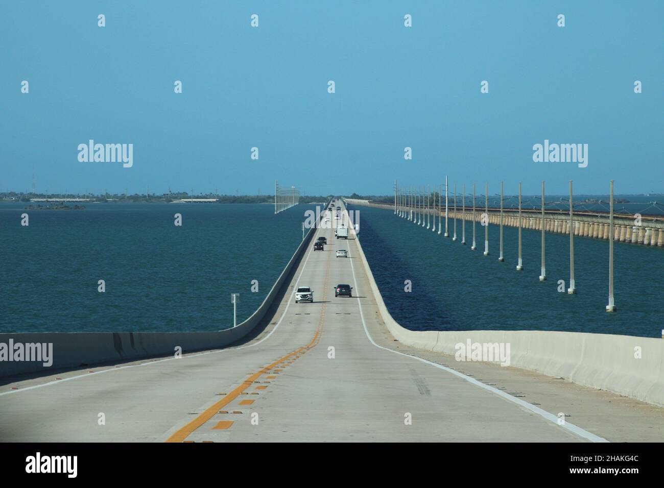 Auto lungo il ponte di sette miglia, con le Florida Keys sullo sfondo e l'acqua blu del Golfo del Messico Foto Stock