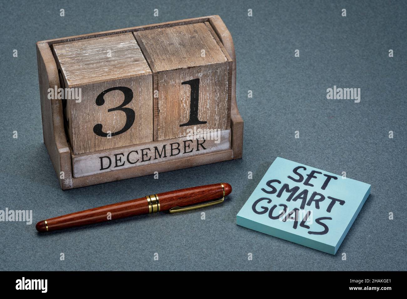 Imposta obiettivi Smart - concetto di risoluzioni di Capodanno, scrittura a mano su una nota di promemoria con calendario a blocchi di legno con data dicembre 31 Foto Stock