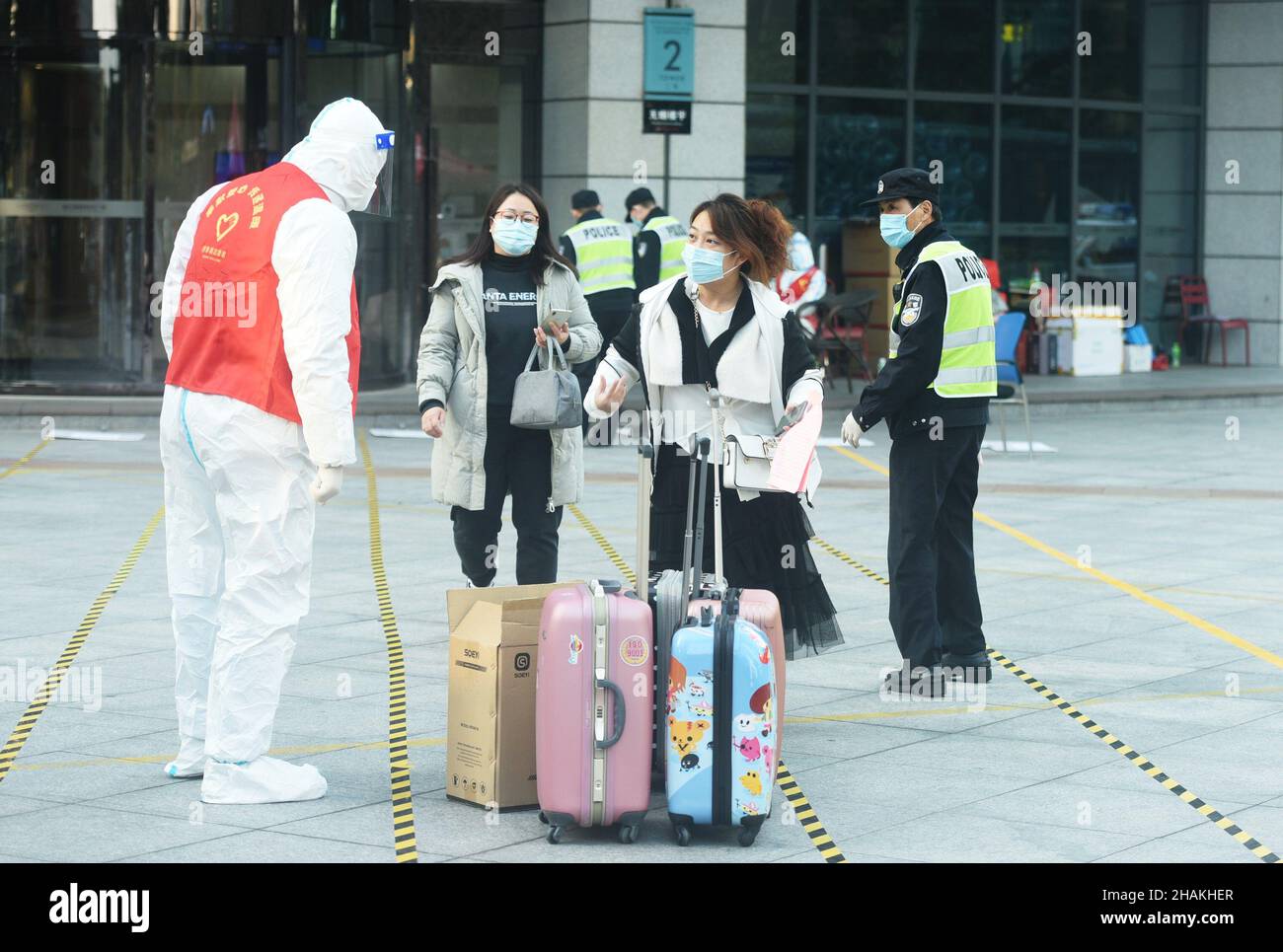 HANGZHOU, CINA - 13 DICEMBRE 2021 - le persone in quarantena escono dall'edificio 2 del Qianjiang International Times Square a Hangzhou, provincia dello Zhejiang Foto Stock