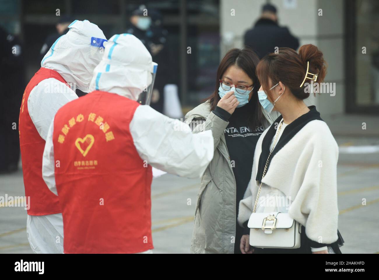 HANGZHOU, CINA - 13 DICEMBRE 2021 - le persone in quarantena escono dall'edificio 2 del Qianjiang International Times Square a Hangzhou, provincia dello Zhejiang Foto Stock