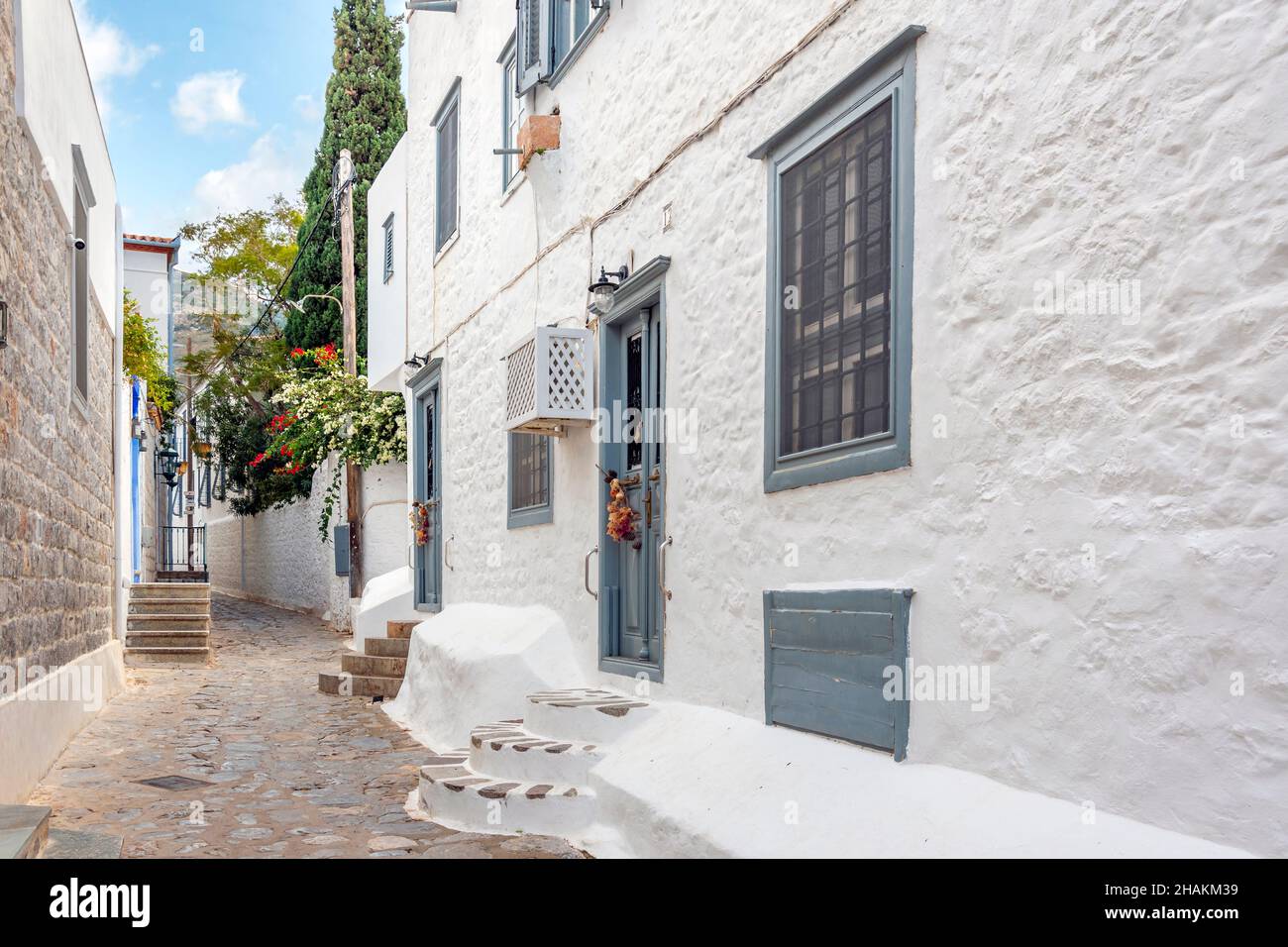 Una strada pittoresca di case e negozi imbiancati nel villaggio della piccola isola greca di Idra, Grecia. Foto Stock