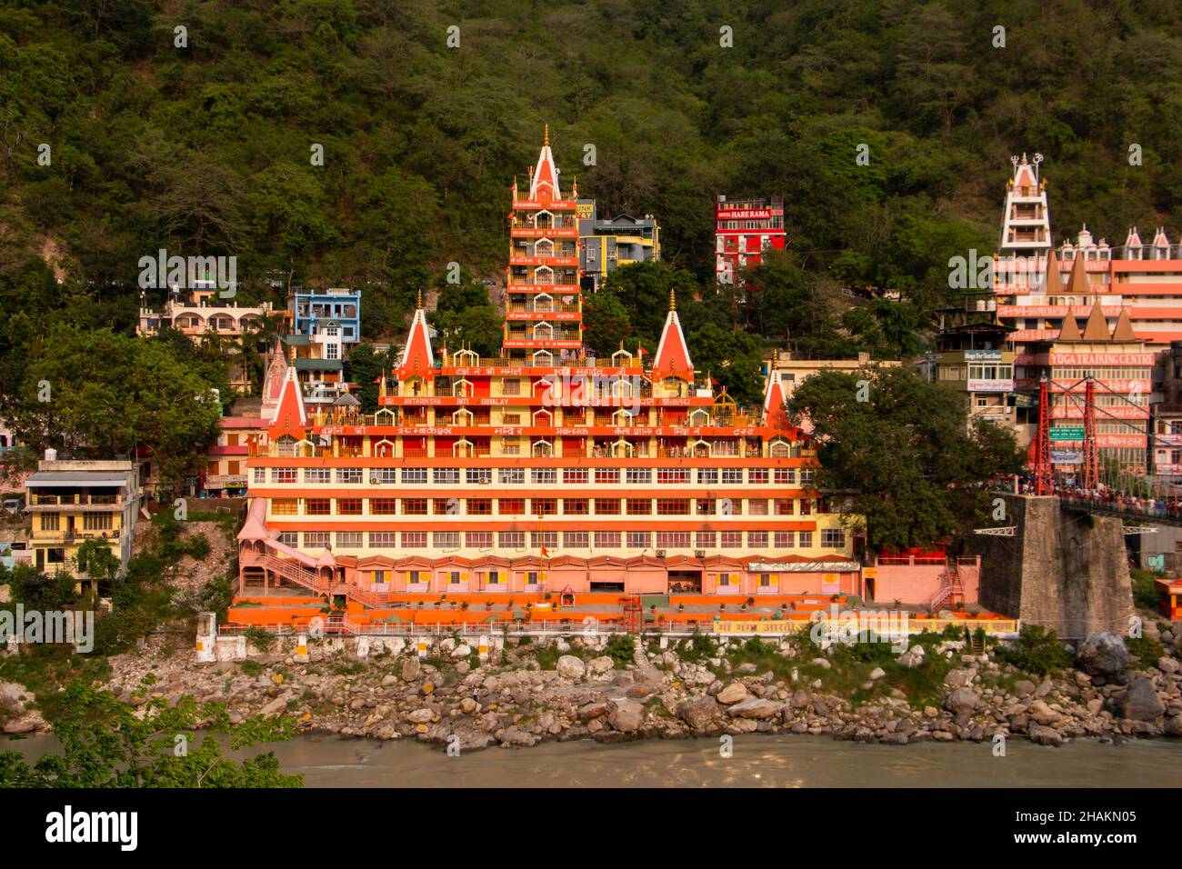 Vista del fiume Ganga terrapieno, Lakshman Jhula bridge e Tera Manzil tempio, Trimbakeshwar a Rishikesh Foto Stock