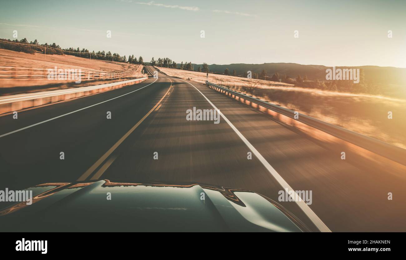 Colorado Country Road Sunset Drive Long Exposure Motion Blur tema durante l'ora d'oro tramonto panoramico. Concetto di automotive e trasporti. Foto Stock