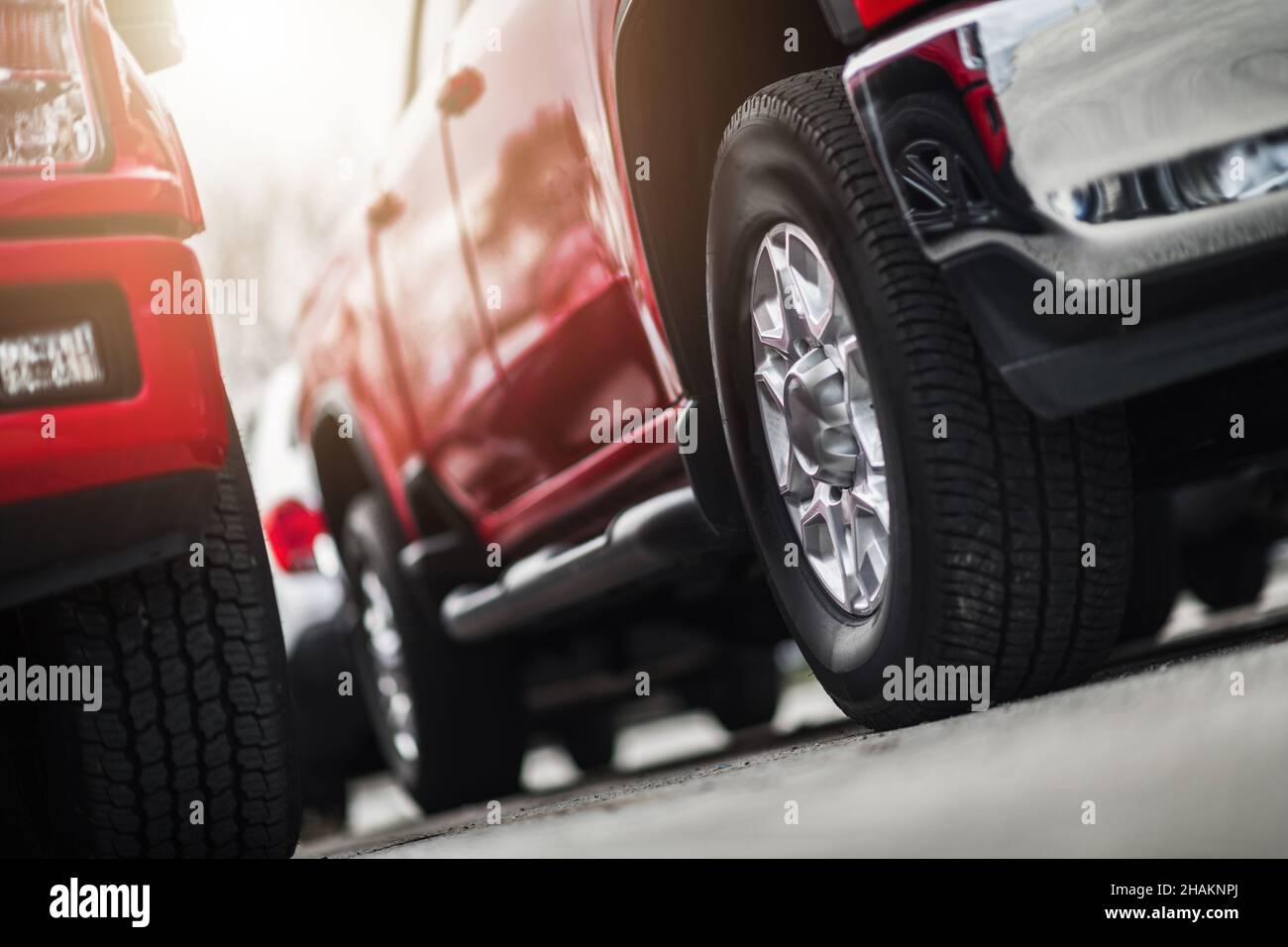 Moderni camion di pick-up in vendita tema di business automobilistico. Scorte della concessionaria. Ruote da terra in primo piano. Foto Stock