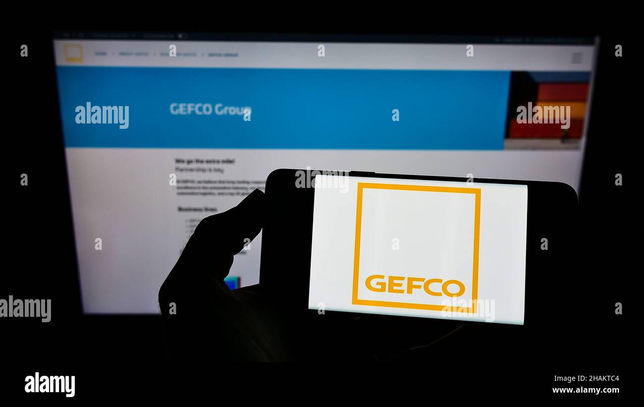 Persona che tiene sullo schermo lo smartphone con il logo della società logistica francese GEFCO Group di fronte al sito web. Mettere a fuoco sul display del telefono. Foto Stock