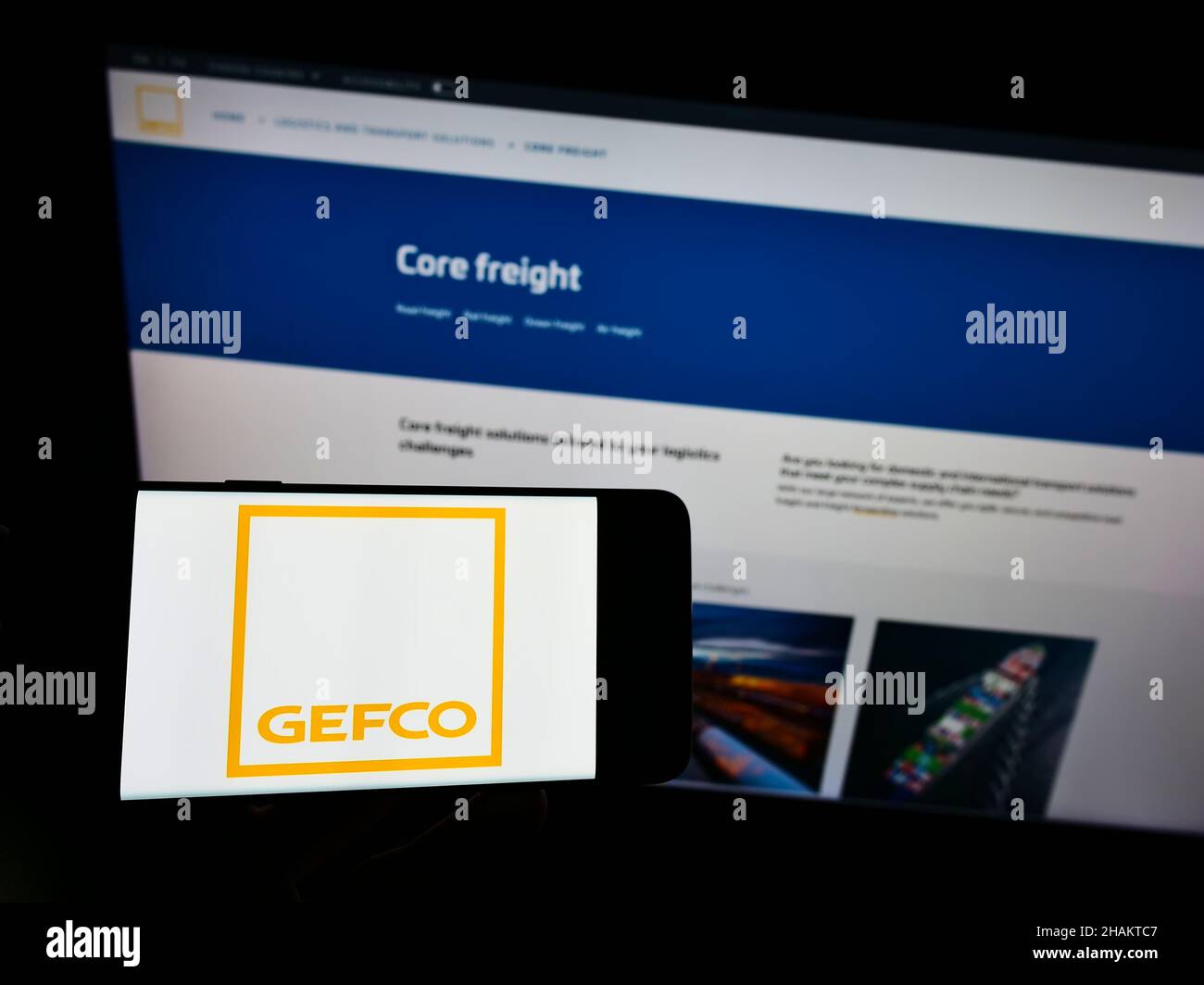 Persona che detiene il cellulare con il logo della società logistica francese GEFCO Group sullo schermo di fronte alla pagina web aziendale. Mettere a fuoco sul display del telefono. Foto Stock