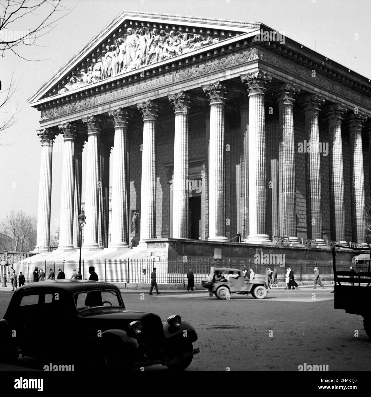 Parigi la Madeleine vicino alla fine della seconda Guerra Mondiale, 1945. Vista della chiesa neoclassica, aperta nel 1842. La posizione della telecamera è attraversata la strada nell'angolo sud-est e raffigura la facciata sud-ovest a colonne complete e alcune delle facciate sud-est. Sulla strada ci sono un camion militare, una jeep militare e una vettura parcheggiata. Circa due dozzine di pedoni sono in vista Foto Stock