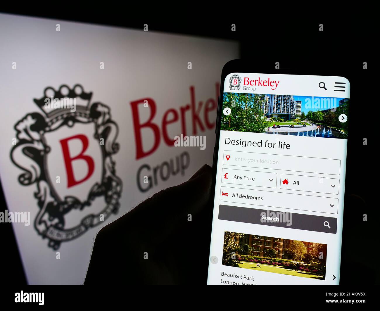 Persona che detiene il cellulare con sito web della società britannica The Berkeley Group Holdings plc su schermo con logo. Concentrarsi sul centro del display del telefono. Foto Stock