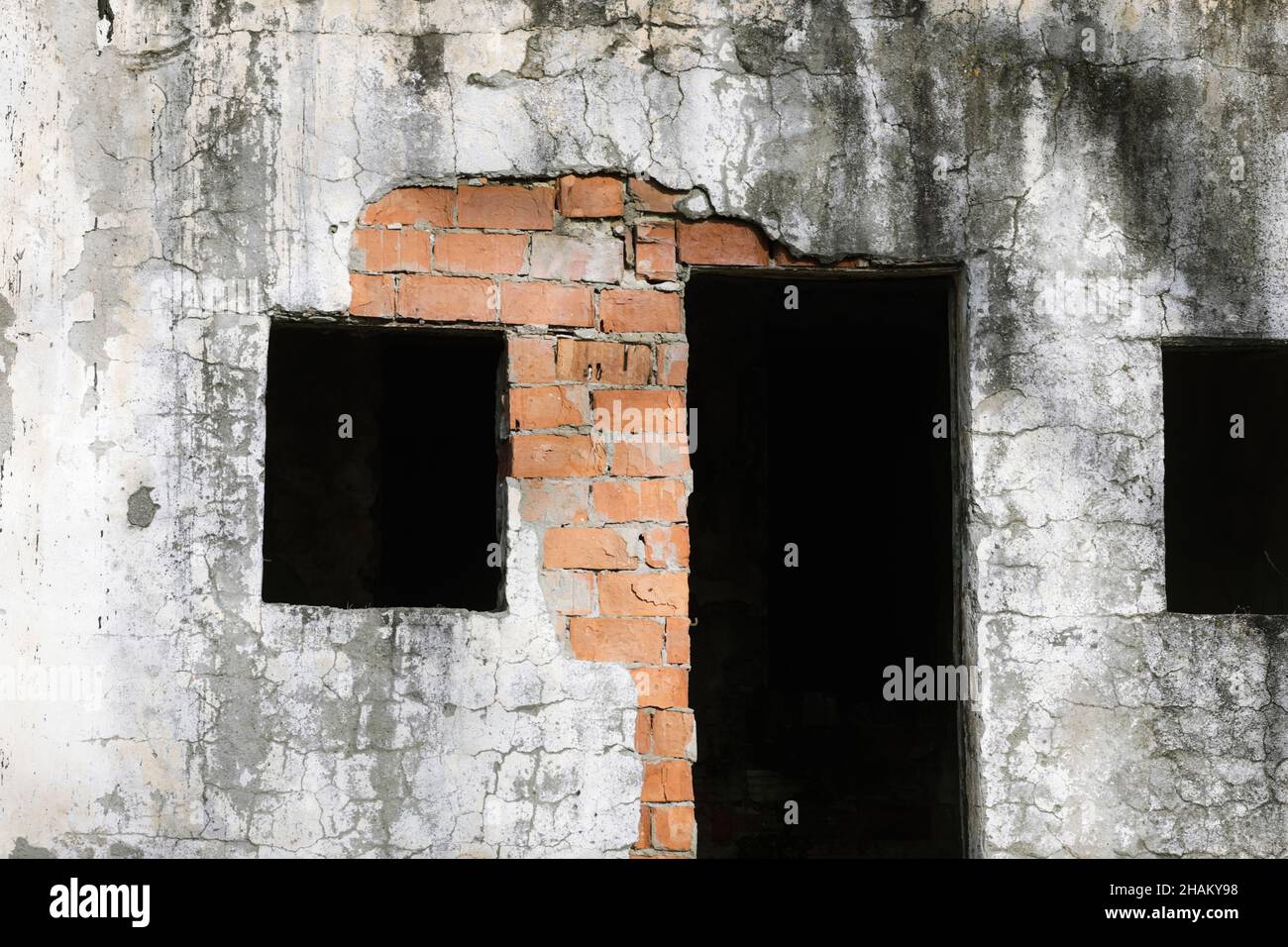 Immagine della profondità di campo poco profonda (fuoco selettivo) con un edificio abbandonato in un campo vicino a una vecchia ferrovia in una giornata invernale. Foto Stock