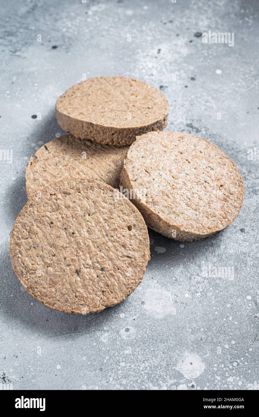 Carne cruda libera pianta a base di polpette di hamburger, cutlets vegetariani. Sfondo grigio. Vista dall'alto Foto Stock