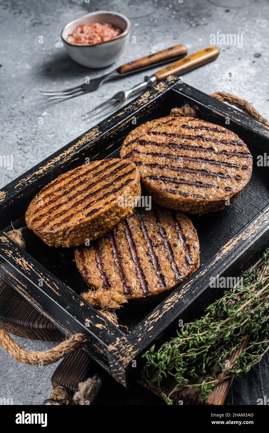 Polpette arrosto senza carne, polpette di hamburger di carne a base di piante in vassoio di legno con erbe. Sfondo grigio. Vista dall'alto Foto Stock