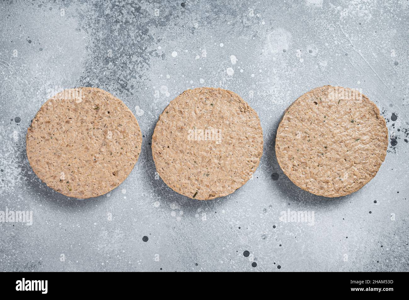 Carne cruda libera pianta a base di polpette di hamburger, cutlets vegetariani. Sfondo grigio. Vista dall'alto Foto Stock