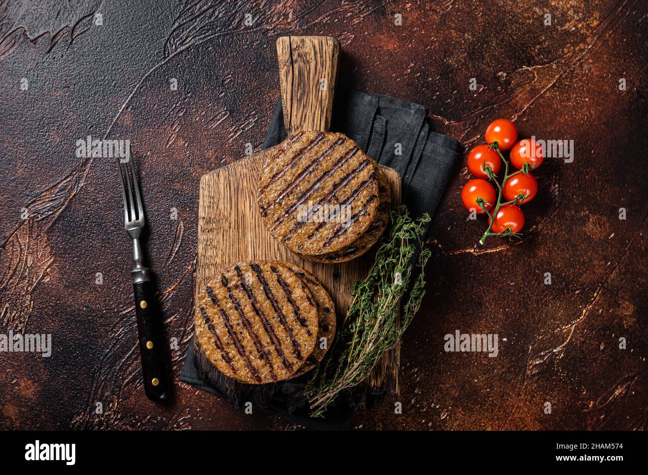 Barbecue grigliate di verdure a base di carne hamburger polpette, tegan cutlets su tavola di legno con erbe. Sfondo scuro. Vista dall'alto Foto Stock
