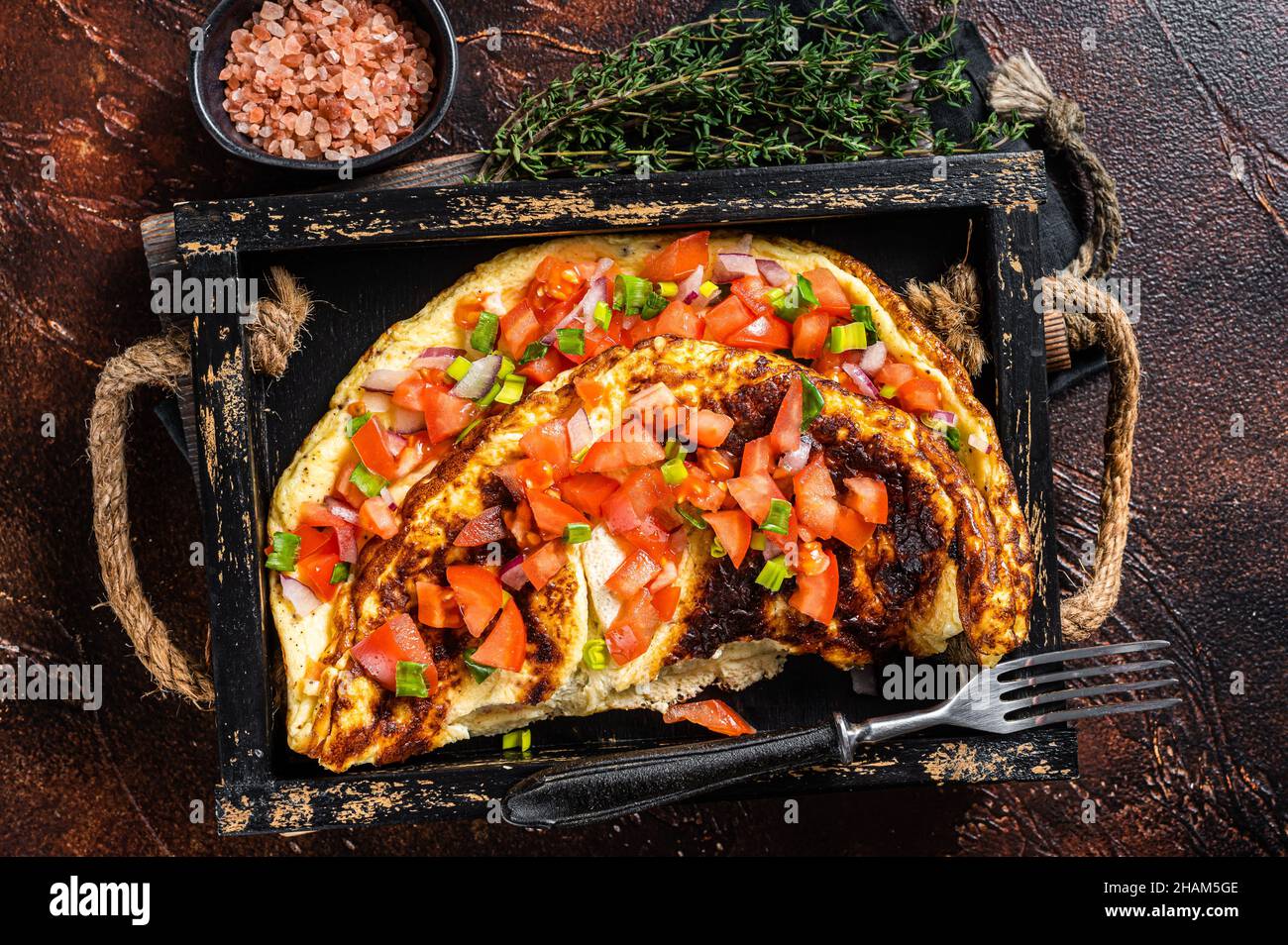 Frittata di uova strapazzate con pomodori, peperone rosso e cipolla. Sfondo scuro. Vista dall'alto Foto Stock