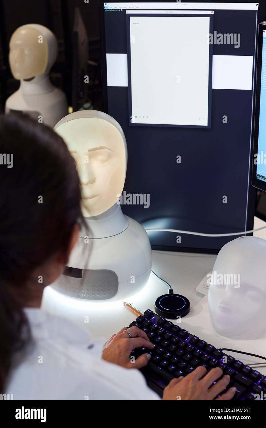 Ingegnere femminile che lavora sul robot Foto Stock