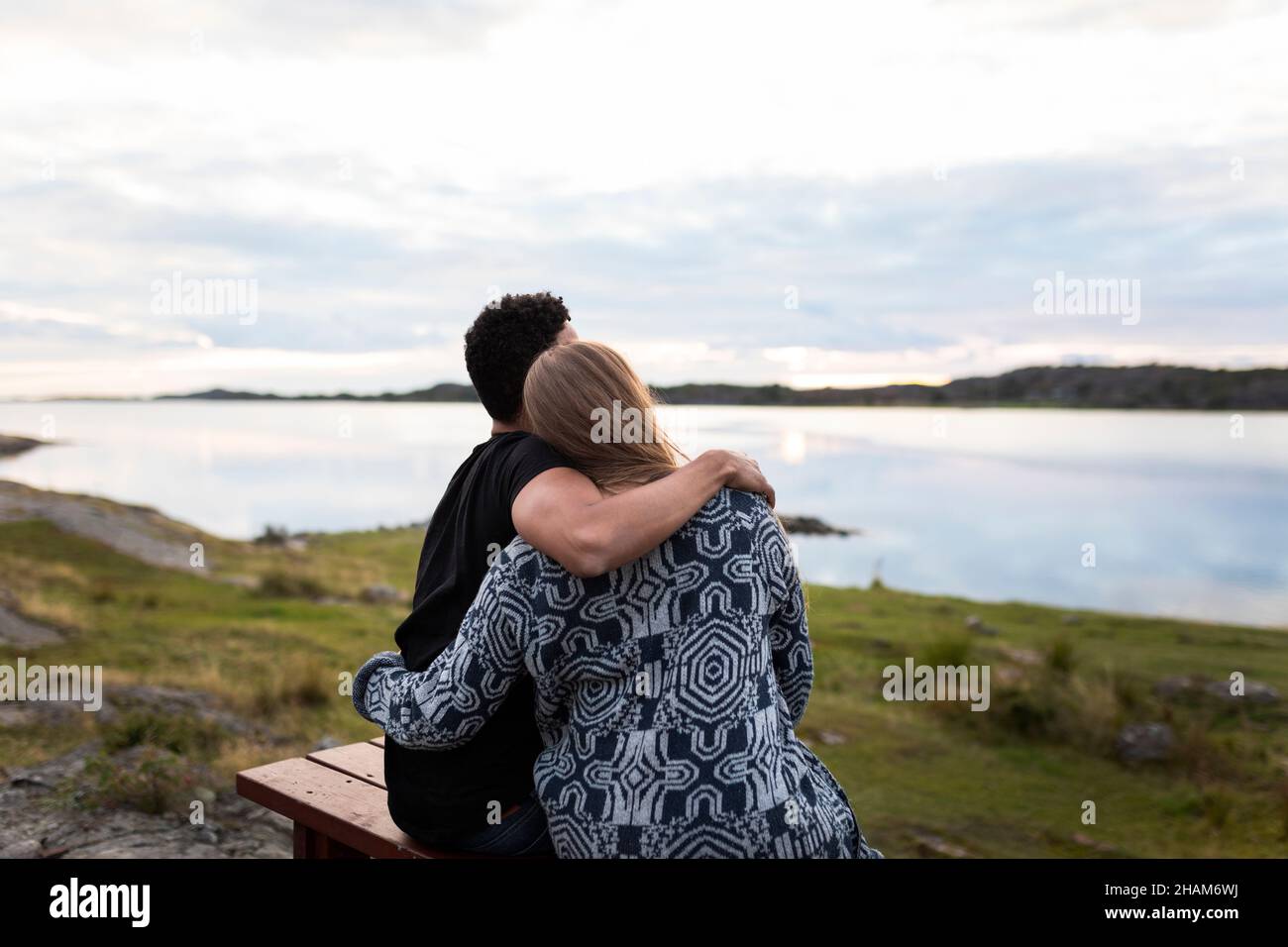 Coppia abbracciando e guardando il lago Foto Stock