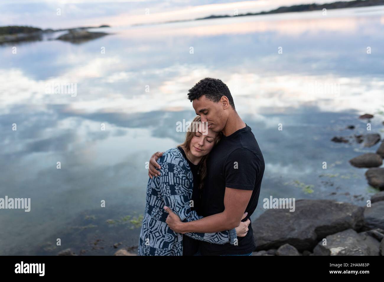 Giovane coppia che abbraccia il lago Foto Stock