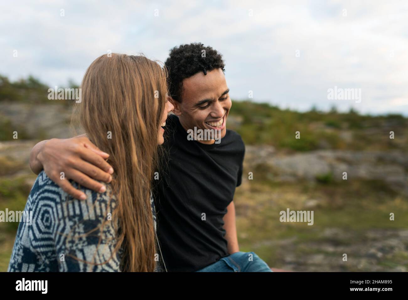 Sorridente giovane coppia abbracciante nella natura Foto Stock