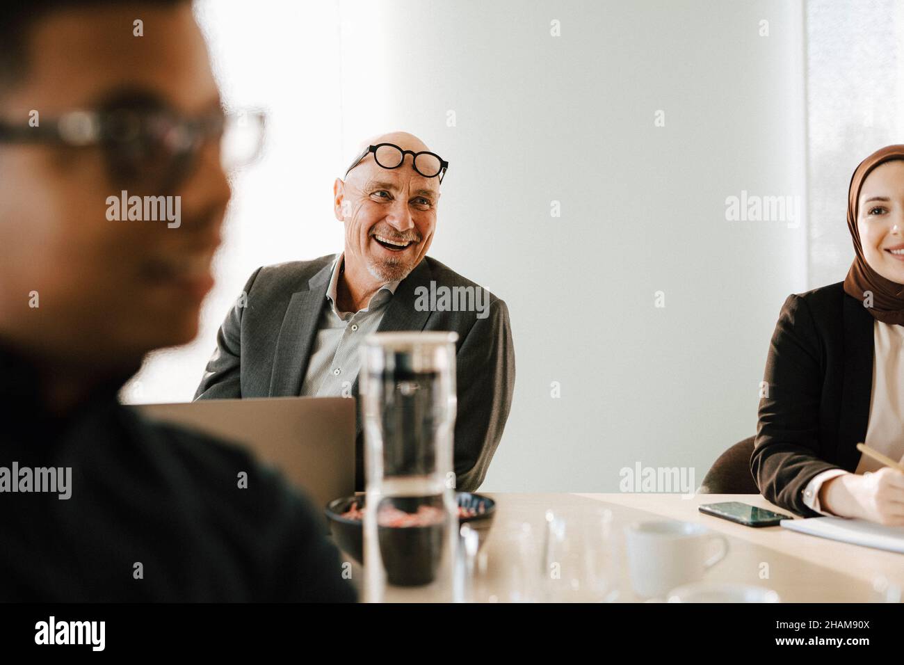 Uomo sorridente alla riunione d'affari Foto Stock