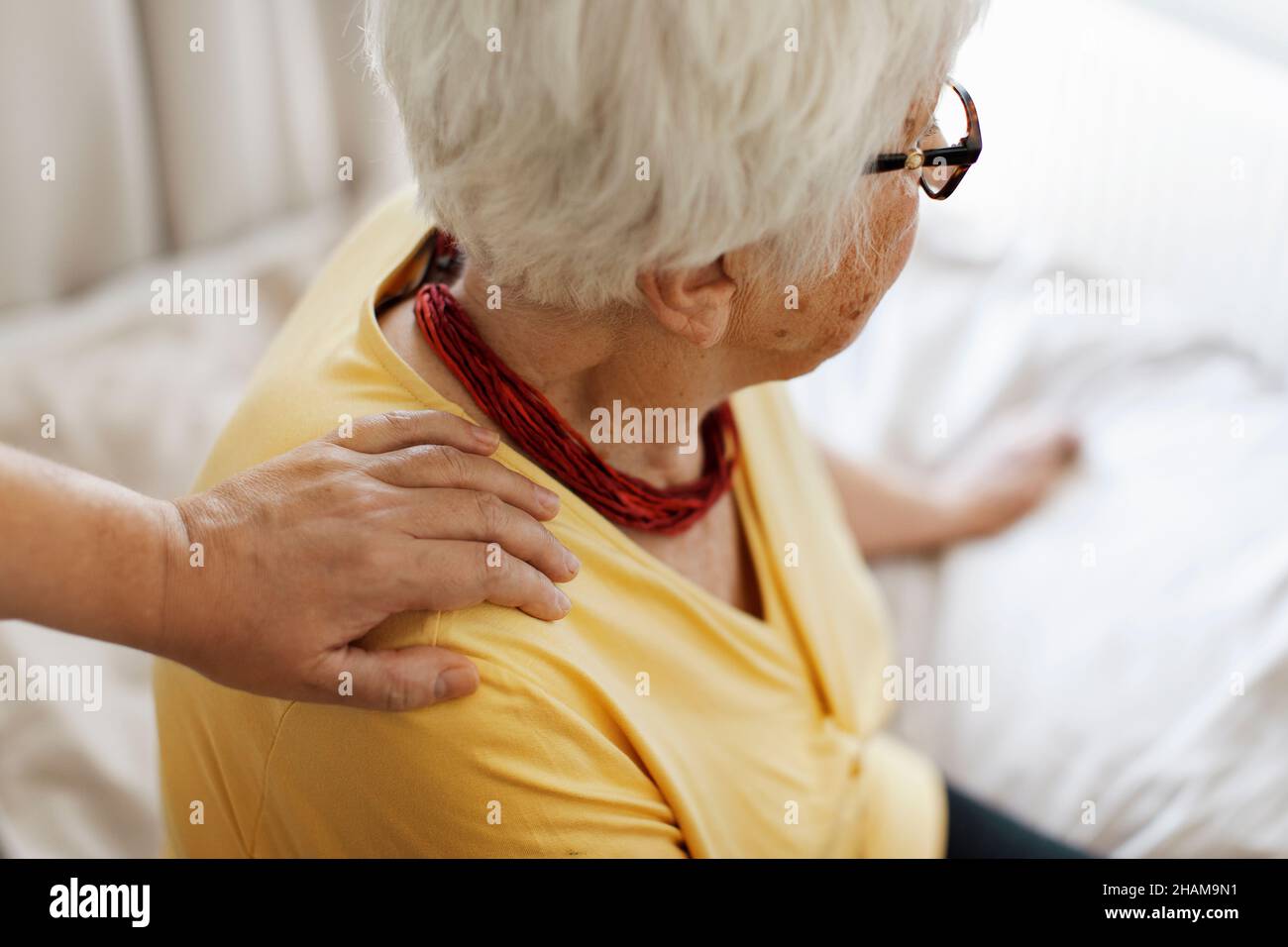 Mano sulla spalla della donna anziana Foto Stock