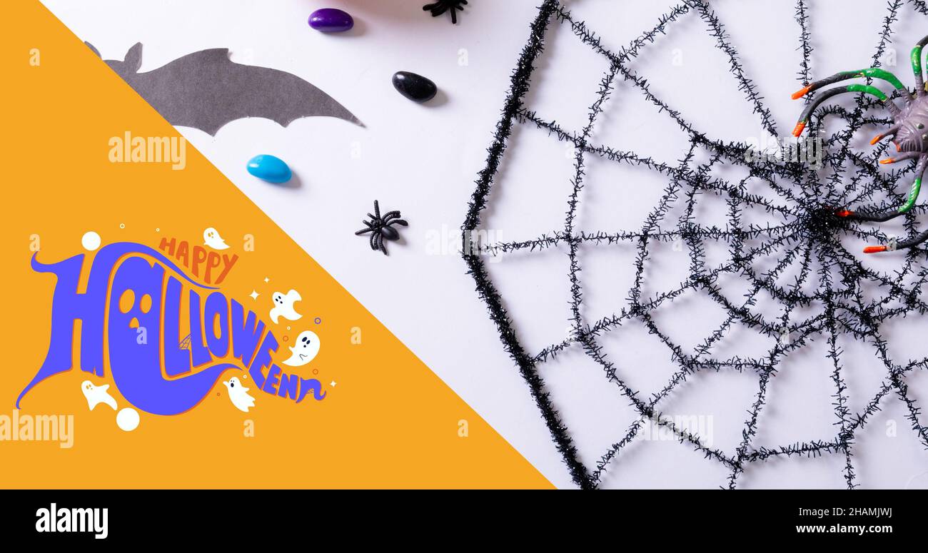 Vista dall'alto del saluto happy halloween sopra il ragno spoky decorativo fotoricettore sul tavolo bianco Foto Stock