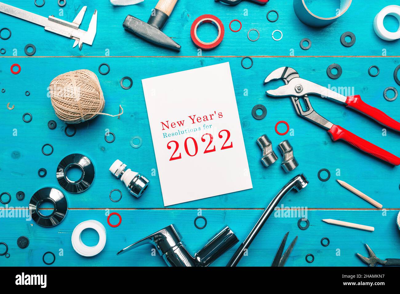 Risoluzioni di Capodanno per il 2022, attrezzi idraulici e notebook in officina, vista dall'alto concetto di posa piatta per la pianificazione di progetti di miglioramento casa nel nuovo anno Foto Stock