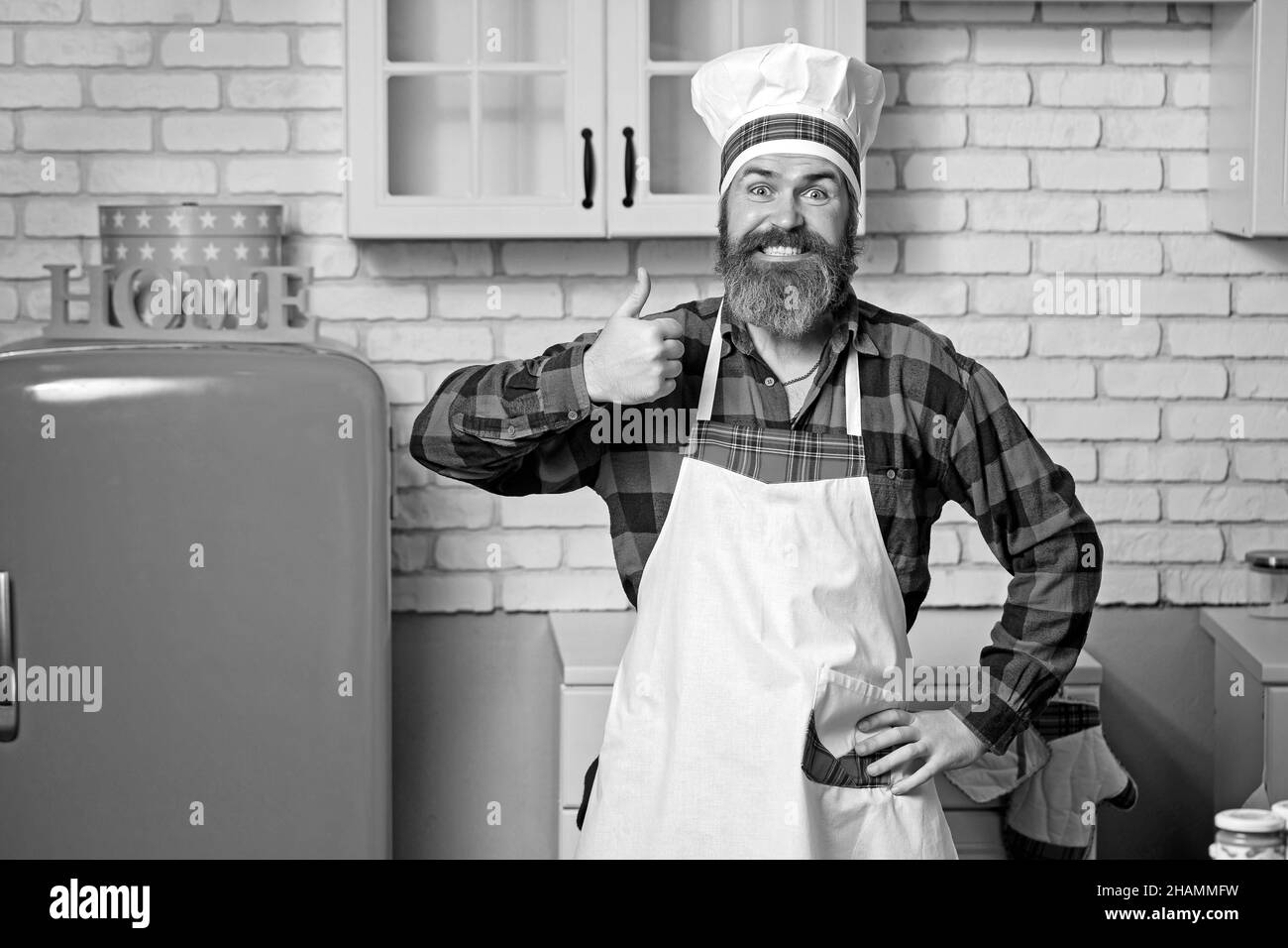 Serio soddisfatto bearded chef, cuoco o panettiere gesturing eccellente. Foto Stock