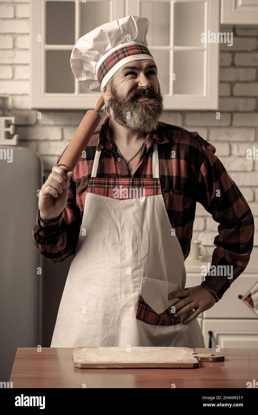 Ritratto di uno chef maschile sorridente con cibo cotto in cucina. Foto Stock