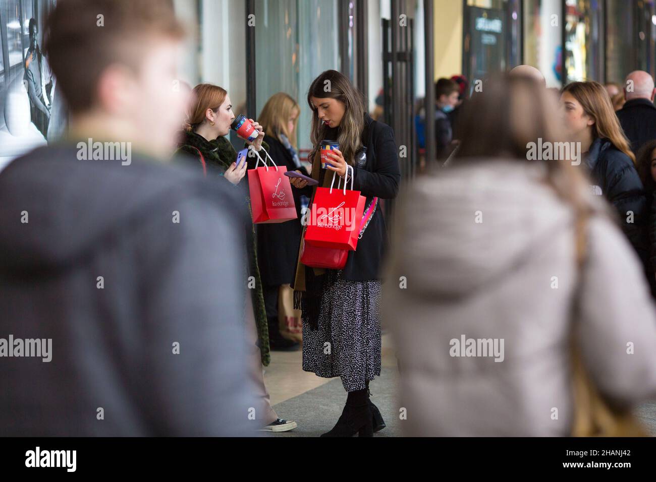 Gli acquirenti sono visti come persone si riuniscono a Covent Garden nel centro di Londra. Foto Stock