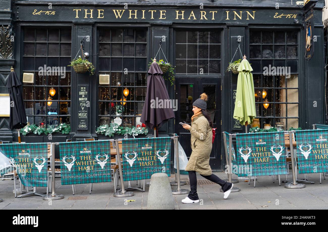 Edimburgo, Scozia, Regno Unito. 14th dicembre 2021. Vedute generali dei negozi e dei bar nel centro di Edimburgo il giorno in cui il primo ministro scozzese ha reso una dichiarazione al Parlamento scozzese sulle restrizioni sociali per controllare l'attuale aumento della variante Omicron nei casi di Covid-19 in Scozia. PIC; i membri del pubblico camminano attraverso i bar nella zona di Grassmarket uno la città. Iain Masterton/Alamy Live News. Foto Stock