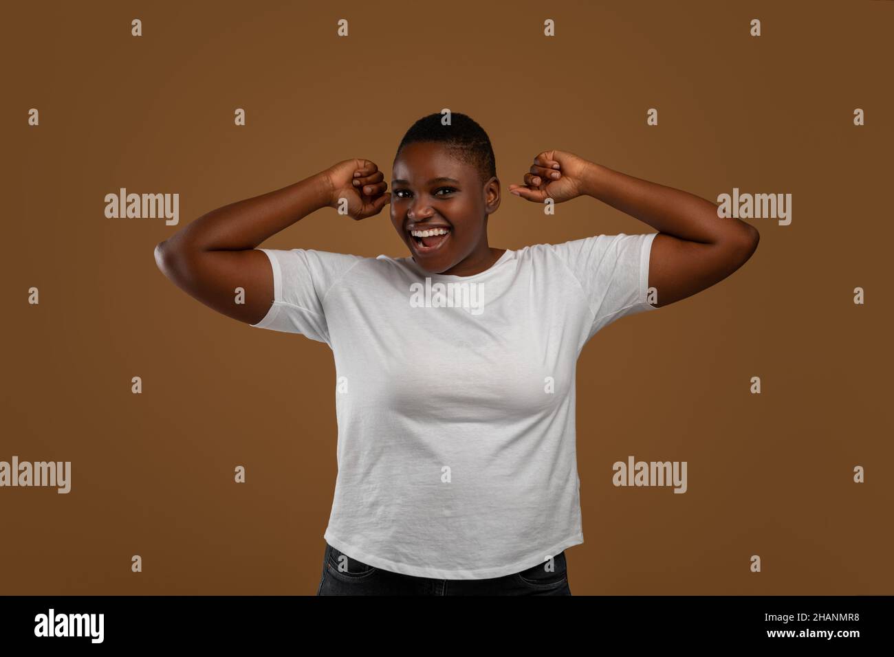 Ritratto della donna nera emozionale che si acclama e balla Foto Stock