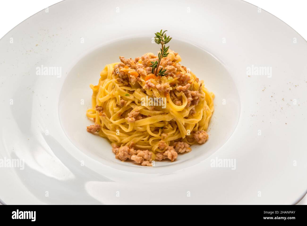 Il tajarin piemontese, i tagliolini sono una pasta all'uovo fresca della tradizione culinaria delle Langhe, condita con ragù di salsiccia in un piatto bianco Foto Stock