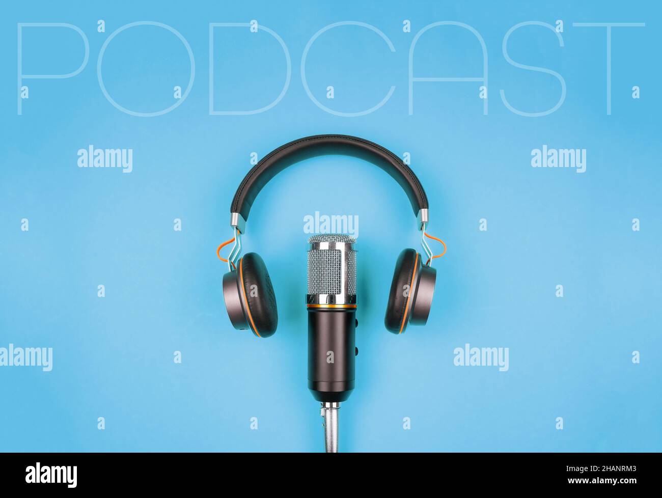 concetto di podcasting, vista direttamente sopra le cuffie e microfono di registrazione su sfondo blu Foto Stock