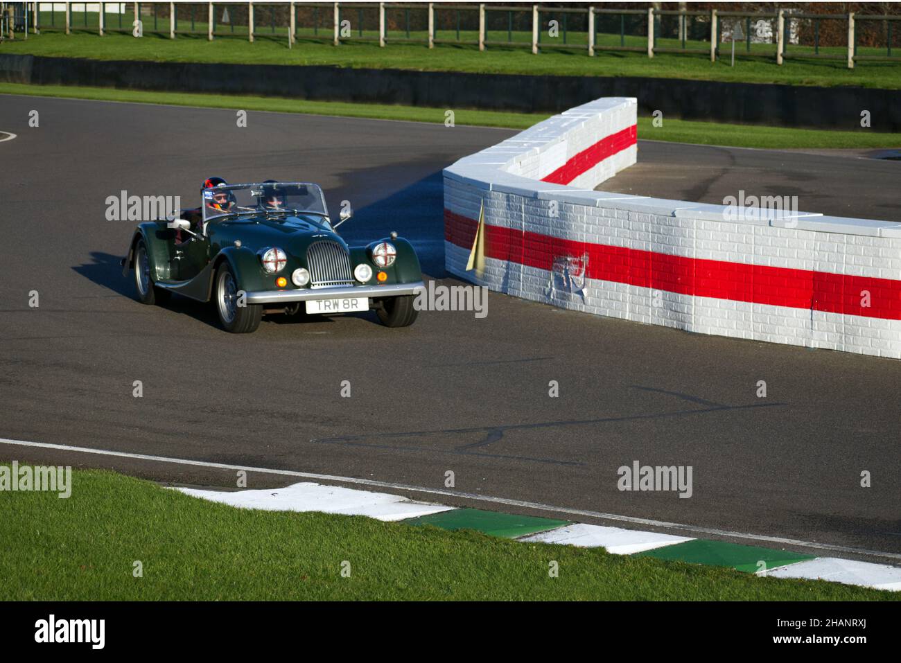Un classico Green Morgan aperto alle auto sportive che entrano nella chicane a Goodwood. Foto Stock