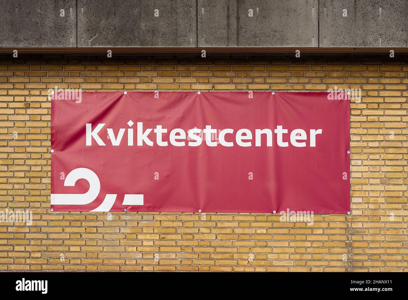 Segno rosso di un centro di test rapido in Danimarca su un muro di mattoni gialli, Frederikssund, Danimarca, 14 dicembre 2021 Foto Stock