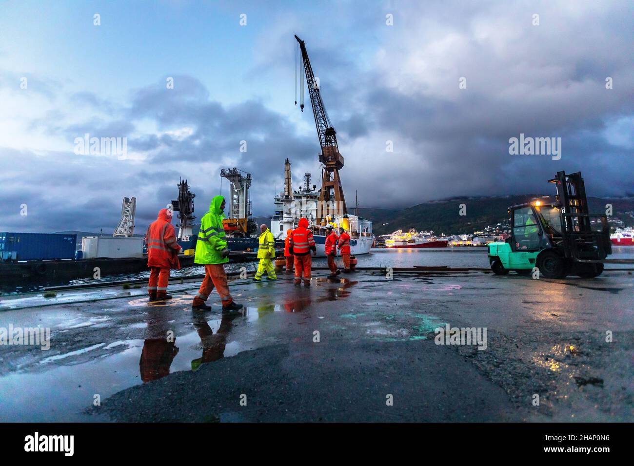 Lavoratori in un bacino di arenaria del vecchio cantiere BMV a Laksevaag, vicino al porto di Bergen, Norvegia. Spedire pronto a lasciare il molo. Il Royal Yacht sullo sfondo, p. Foto Stock