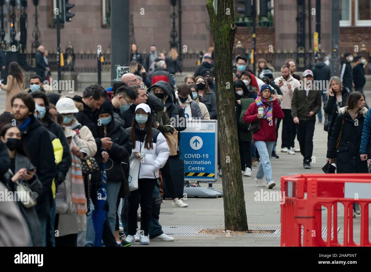 Manchester, Regno Unito, 14th dicembre 2021. I membri del thr pubblico fanno la fila ad un centro di vaccinazione nel centro di Manchester mentre i timori aumentano che la variante di Omicron costringerà il governo a chiudere le parti dell'economia. Credit: Jon Super/Alamy Live News. Foto Stock