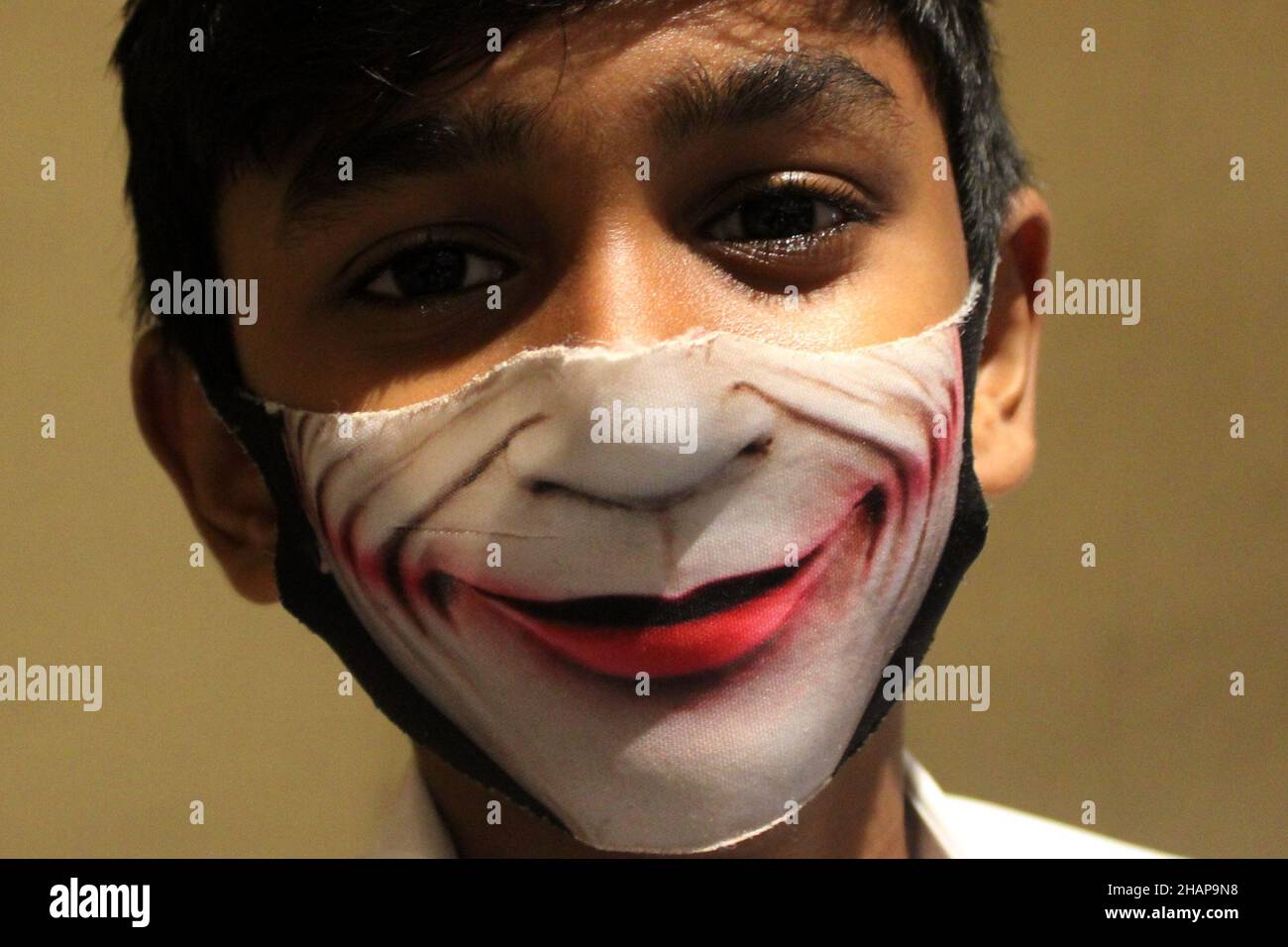 Chennai, Tamil Nadu, India. 14th Dic 2021. Un ragazzo della scuola ha visto indossare un Joker (un super criminale che appare nei fumetti americani pubblicati da DC Comics) impressed maschera protettiva del viso in Chennai. (Credit Image: © Sri Loganathan/ZUMA Press Wire) Foto Stock