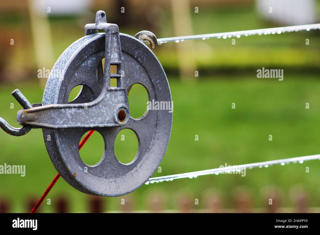 Primo piano di una puleggia di clothesline, gocce di acqua piovana sulla linea di clothesline. Foto Stock