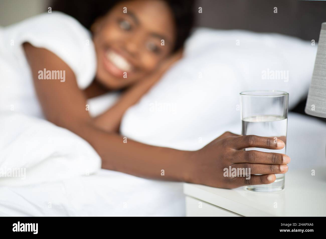 Focalizzazione selettiva sul bicchiere d'acqua al posto letto Foto Stock