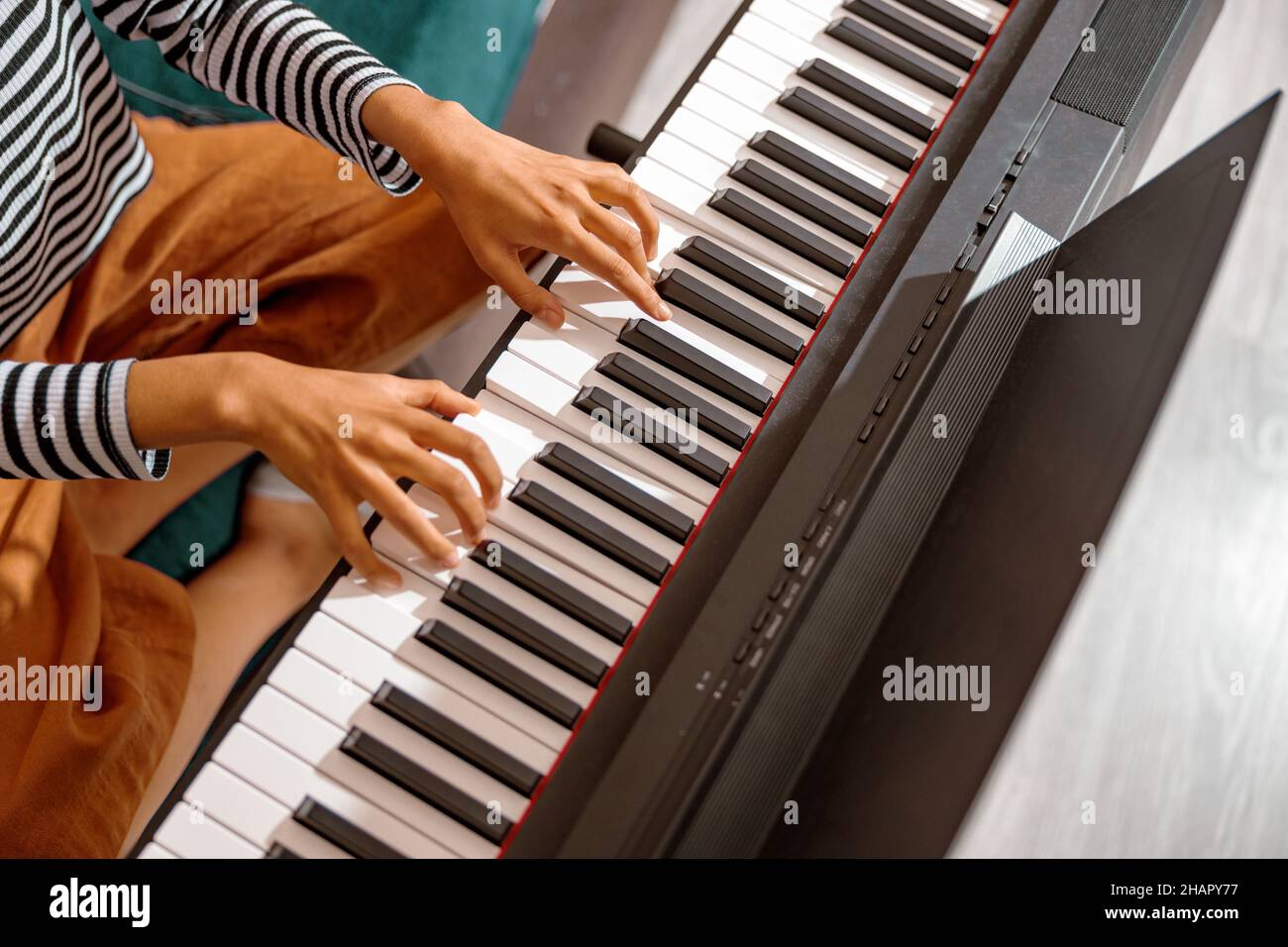 Le mani di una musicista femminile suonano sulla tastiera del sintetizzatore Foto Stock
