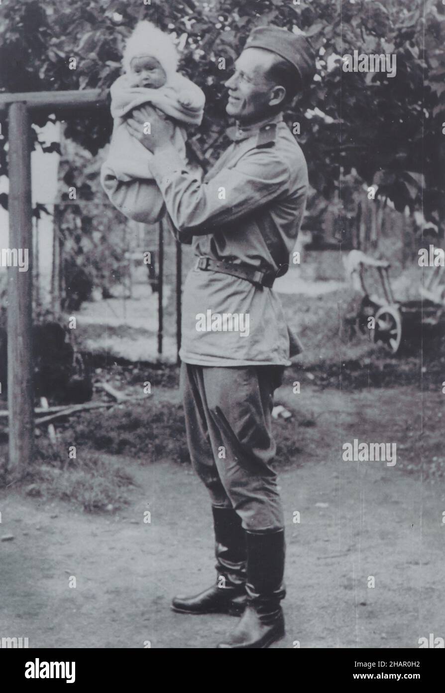 Soldato dell'esercito rosso che tiene un bambino raffigurato nella fotografia d'epoca in bianco e nero da un fotografo sconosciuto datato probabilmente dal 1945 e preso probabilmente in Cecoslovacchia. Foto Stock