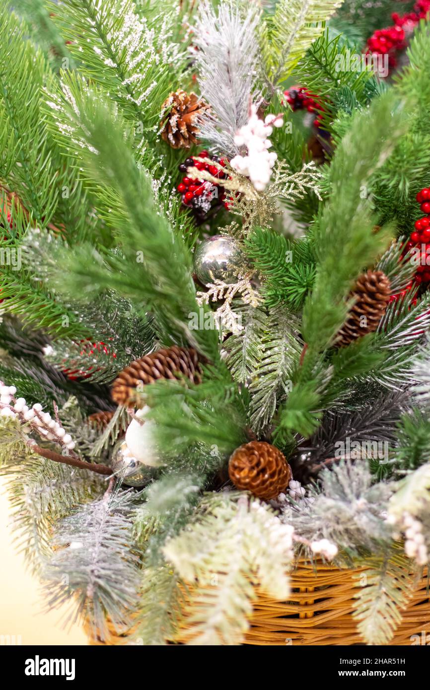 Cestino con decorazioni natalizie. Rametti di alberi di Natale verdi con coni e giocattoli. Foto Stock