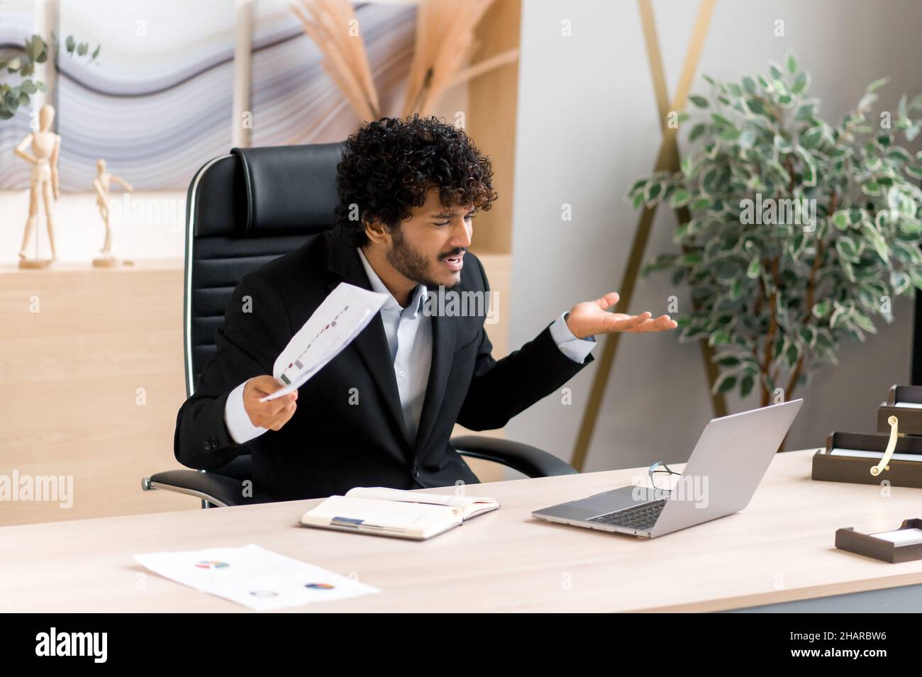 Emotivo arrabbiato infastidito CEO, manager, dipendente indiano o arabo, infastidito a parlare con un collega tramite collegamento video, giuramento per prestazioni scadenti, espressione facciale dispiaciuta, gesti delle mani Foto Stock