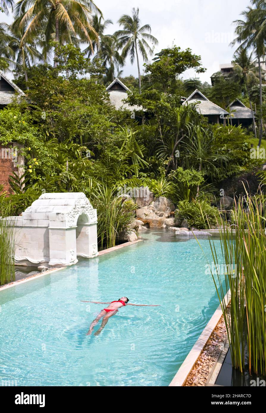 Donna in piscina a Kamalaya, Koh Samui, Thailandia. Una donna che galleggia nella piscina principale del resort Kamalaya. Foto Stock